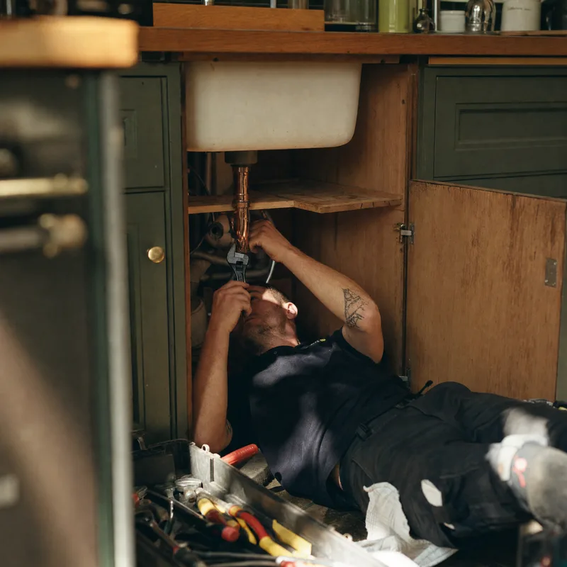 Plumber working under a kitchen sink